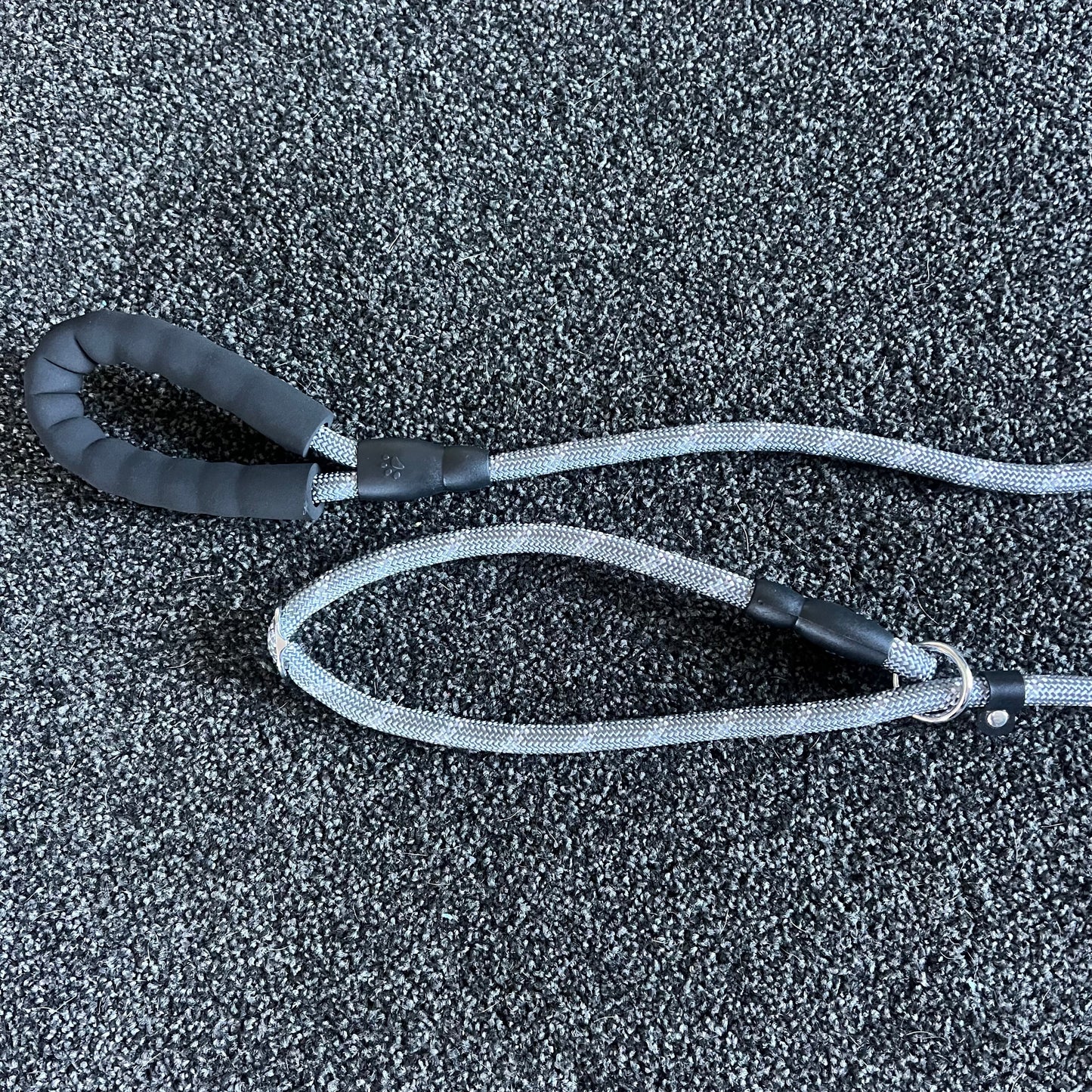 Black and gray dog leash on a textured black surface
