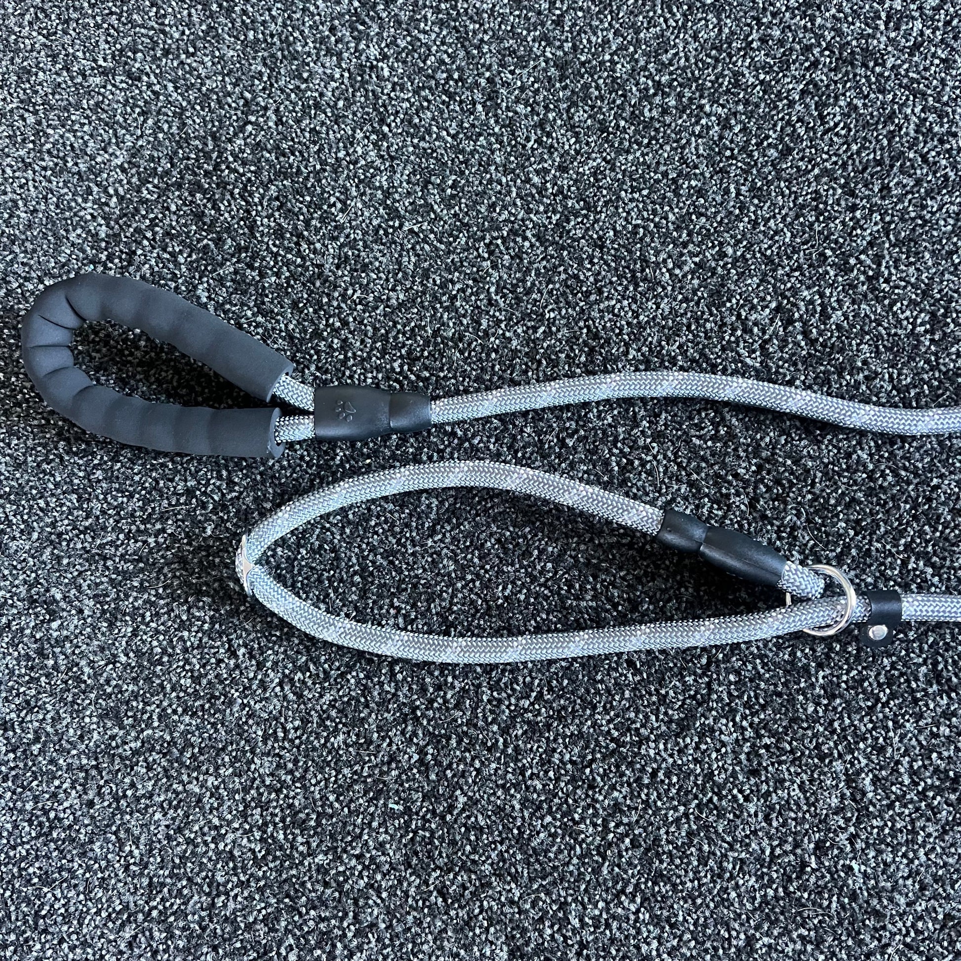 Black and gray dog leash on a textured black surface