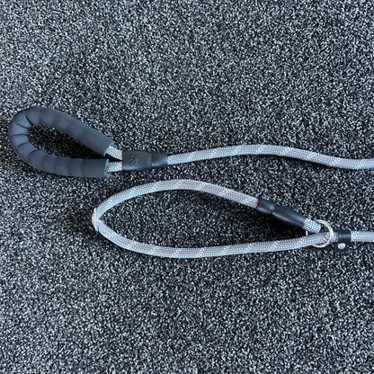 Black and gray dog leash on a textured black surface